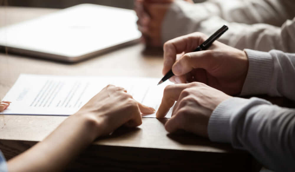 Solicitor Helping Elderly Person Sign A Legal Document